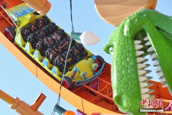 4月26日，上海迪士尼度假区迎来了乐园的第七个主题园区“迪士尼·皮克斯玩具总动员”主题园区全新开幕。据了解，新园区包括三个全新的景点——弹簧狗团团转、抱抱龙冲天赛车和胡迪牛仔嘉年华，一个独特的与迪士尼朋友见面的主题区域——友情驿站，以及提供沉浸式购物和餐饮体验的艾尔玩具店和玩具盒欢宴广场。图为游客在园区内游玩。<a target='_blank' href='U020191008624659121671.com/'>中新社</a>记者 张亨伟 摄