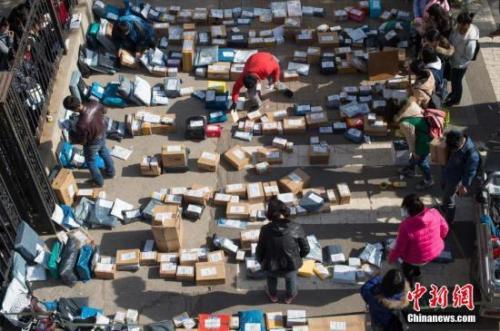 2016年“双11”后各地迎来快递派送高峰。图为工作人员忙着分拣满地的快递。武俊杰 摄